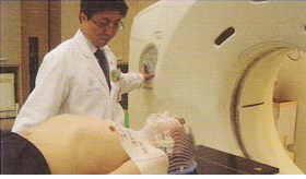 서울아산병원 방사선종양학과 CT simulation 의 촬영 장면으로, 치료대 위에 환자가 누워있고 장비 안으로 들어가 촬영하는 모습