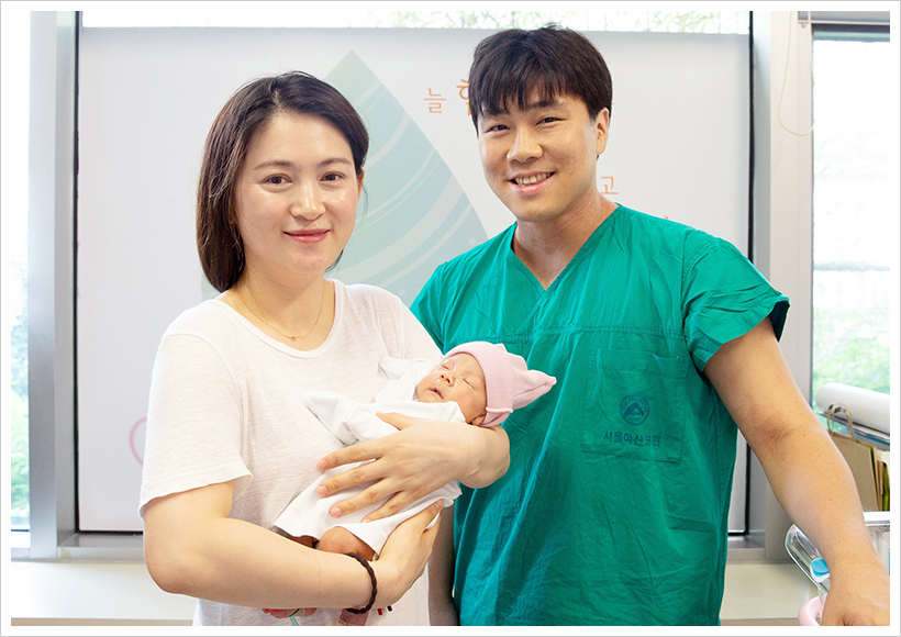 어머니 정향선씨가 전호삼 아기를 안고 주치의인 정의석 교수와 함께 퇴원을 앞두고 기념사진을 찍고 있다.